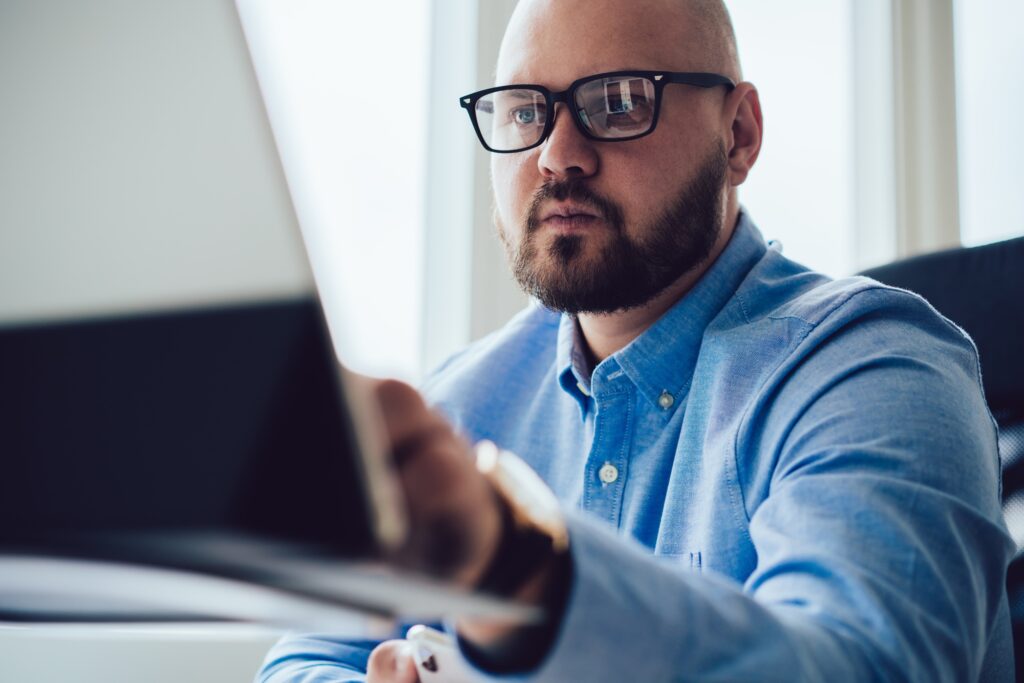 Bearded man working on laptop at desk