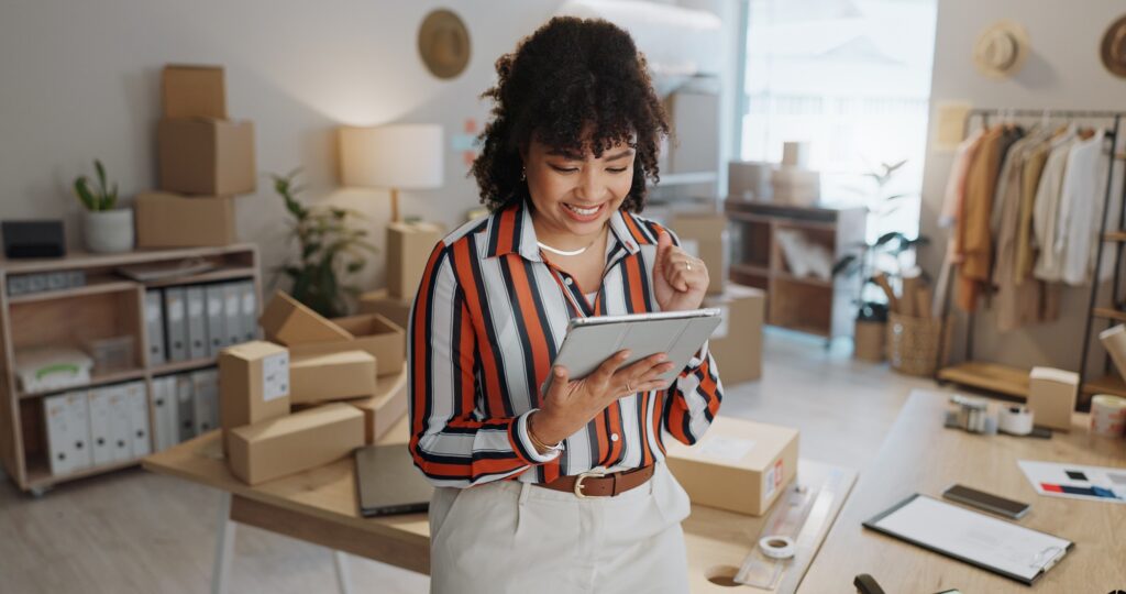 Tablet, small business and woman with success and package and order informationmotivation. Home, en